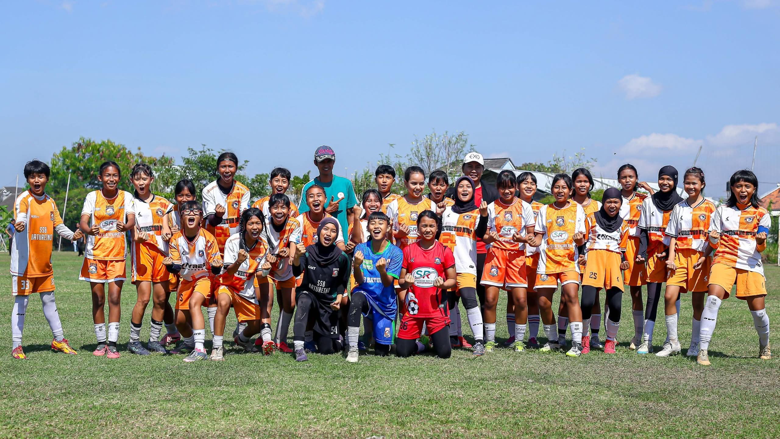 Tim PS Baturetno Women berdiri bersama di lapangan sepak bola